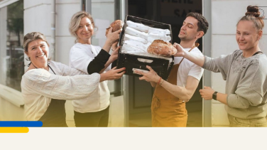 Picture of team of bakers holding a loaf of bread