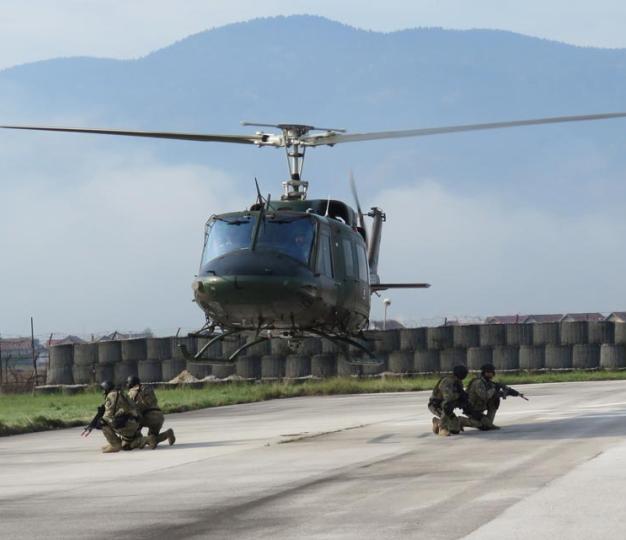helicopter landing with military staff on the ground