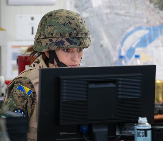 Bosnian woman in helmet by computer