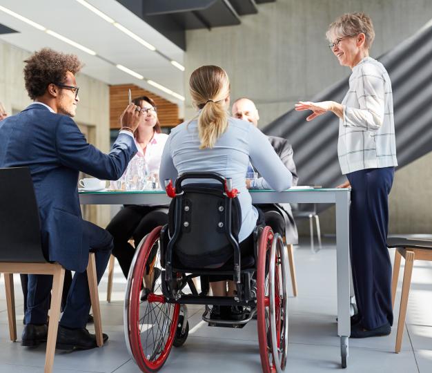 Office workers in a meeting including person in wheelchair