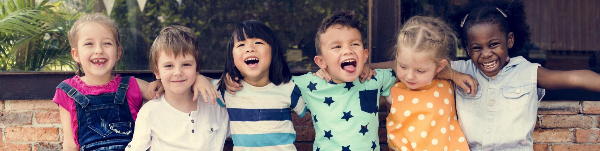 children from different origins together on a bench