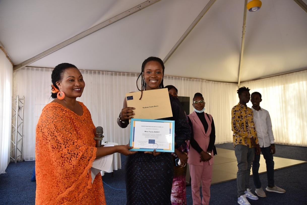 a woman giving a certificate to students 