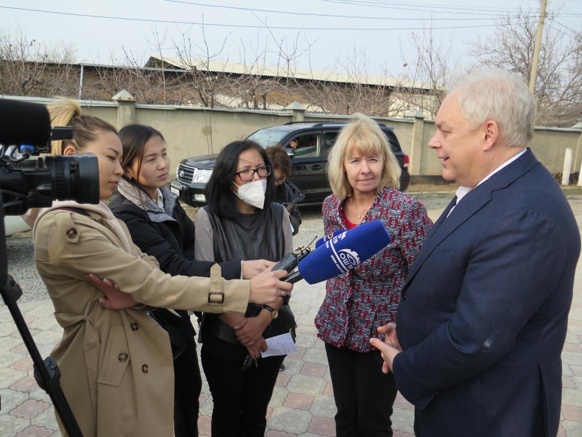 Reporter interviewing a person while three others listen.