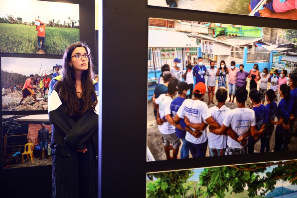 Member of Action Against Hunger looking at the exhibit photos
