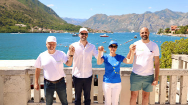 Marta Kos holding hand with other officials for a group photo