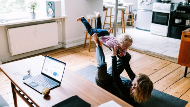 A woman playing with a child in a living room
