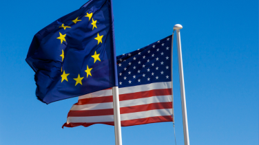 EU and US Flags flying in a clear blue sky