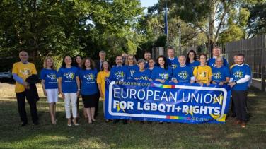 group of people in LGBTIQ+ tshirts with banner