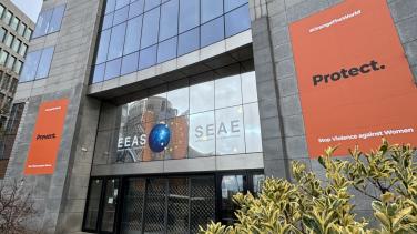 EEAS building with orange Prevent. Protect. banners on facade
