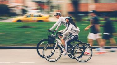 Man and a woman riding bikes on the street