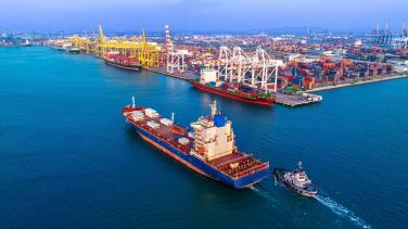 A cargo ship docking in a busy port. 