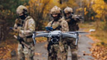 Modern army soldiers using aerial drone for artillery guidance