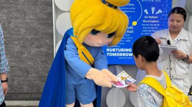 Europa mascot giving an item to a boy