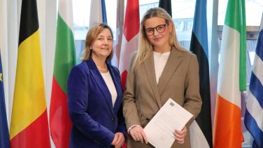 two women standing in front of colourful flags