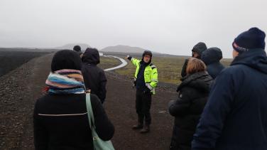 group of people surrounding a guide in a yellow vest