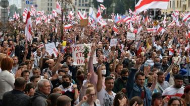 Large protest of people waving Belyorussian flags.