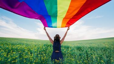 IDAHOT_person_holding_rainbow_flag