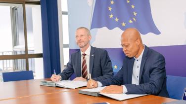 EU Delegation Head of Cooperation signining the agreement with a represenative of an NGO