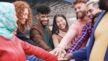 Group of young multiracial people stacking hands (Envato)