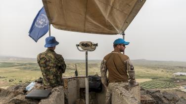 2 UN peacekeepers on a balcony looking at the horizon