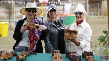 Three women with wooden crafts