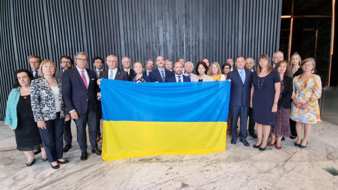 group of people carrying the Ukrainian flag