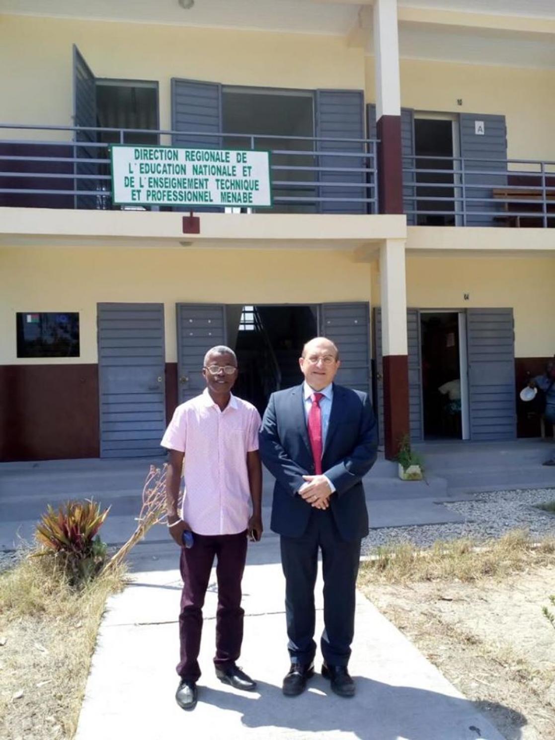 Two people in front of a building