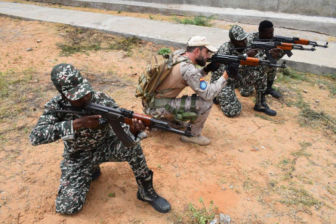Four soldiers crouching with weapons