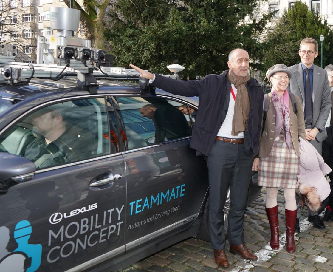 people posing next to a car