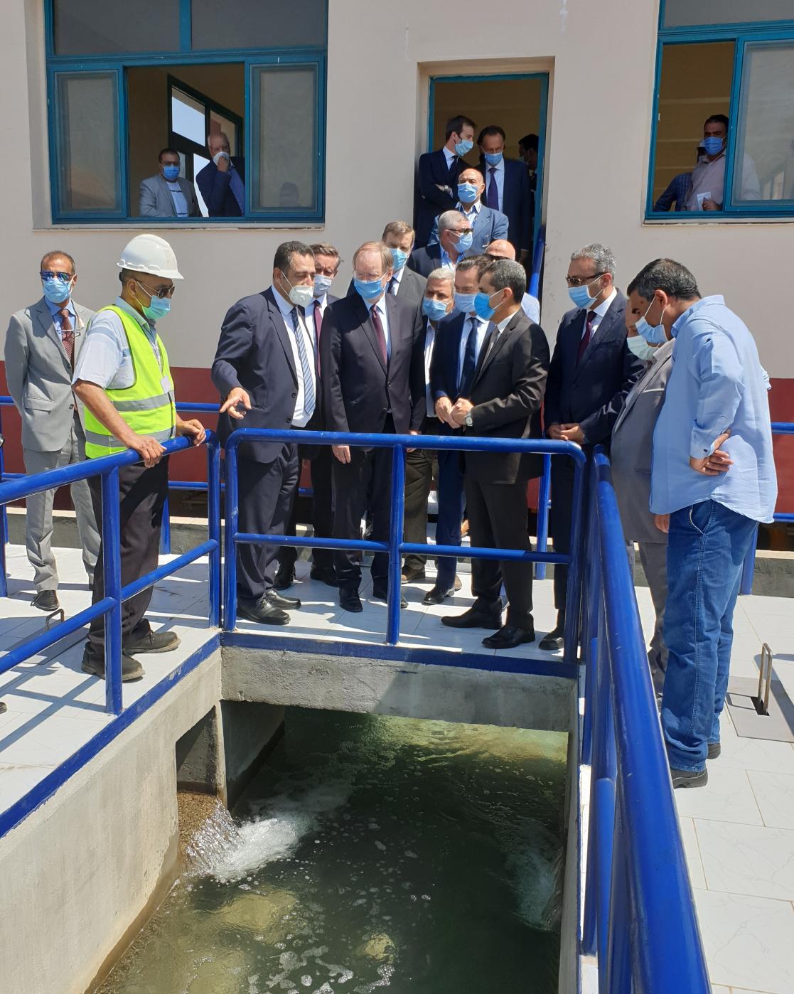 group of people watching a building with water 