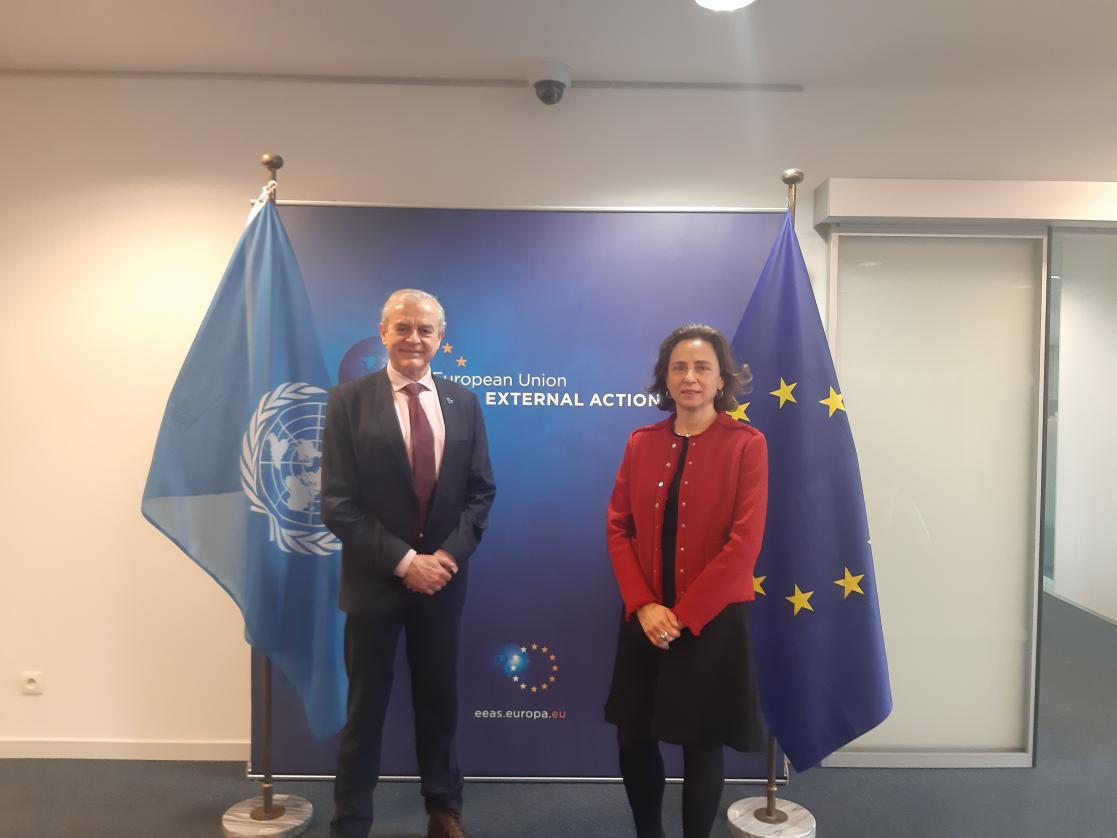Woman and man posing in front of the EU and UNODC flag