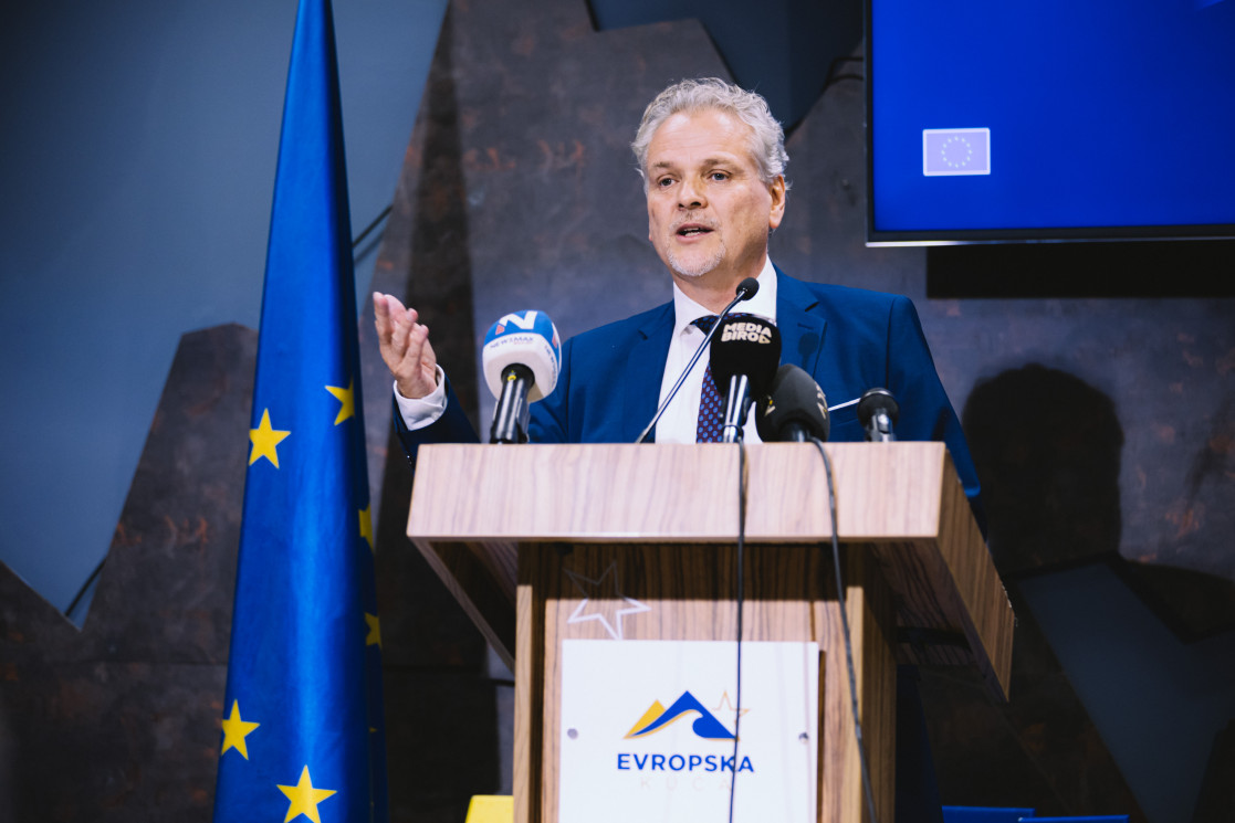 Ambassador Sattler standing behind lectern