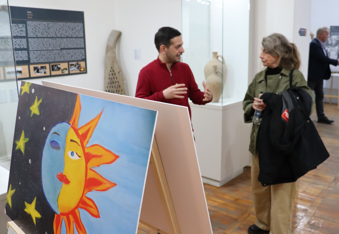 The Sun and the Moon art with people in the background