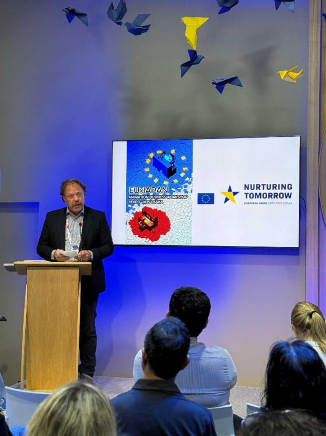 A person on a pedastal addressing an audience. 