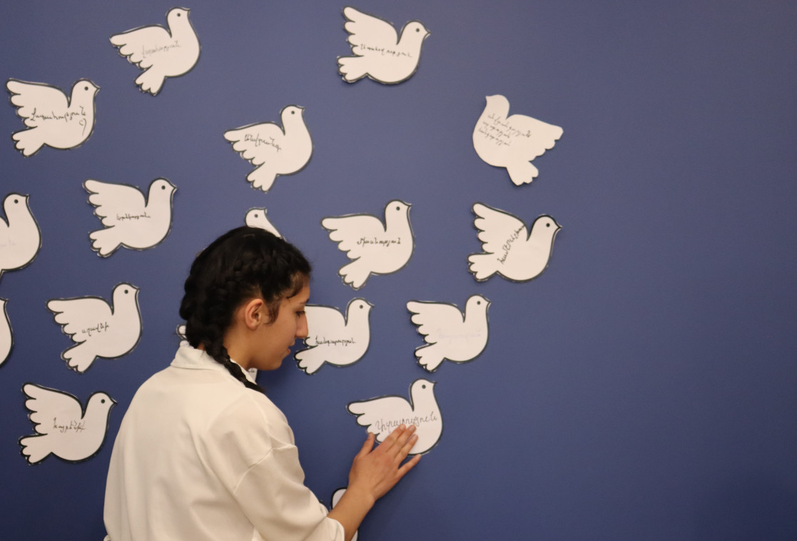 A girl with a peace dove where is written what peace means to her.