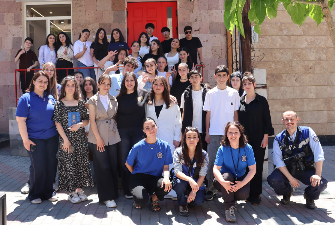 Group photo with youth and EUMA team members in front of youth center.