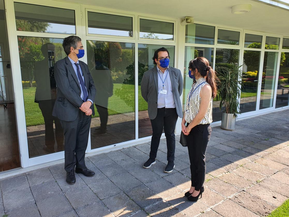 Two men and a woman with sanitary mask talking