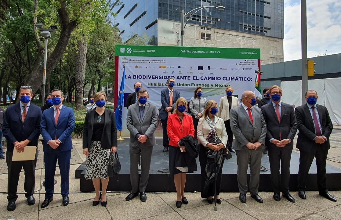 Group of people posing with a poster in the background