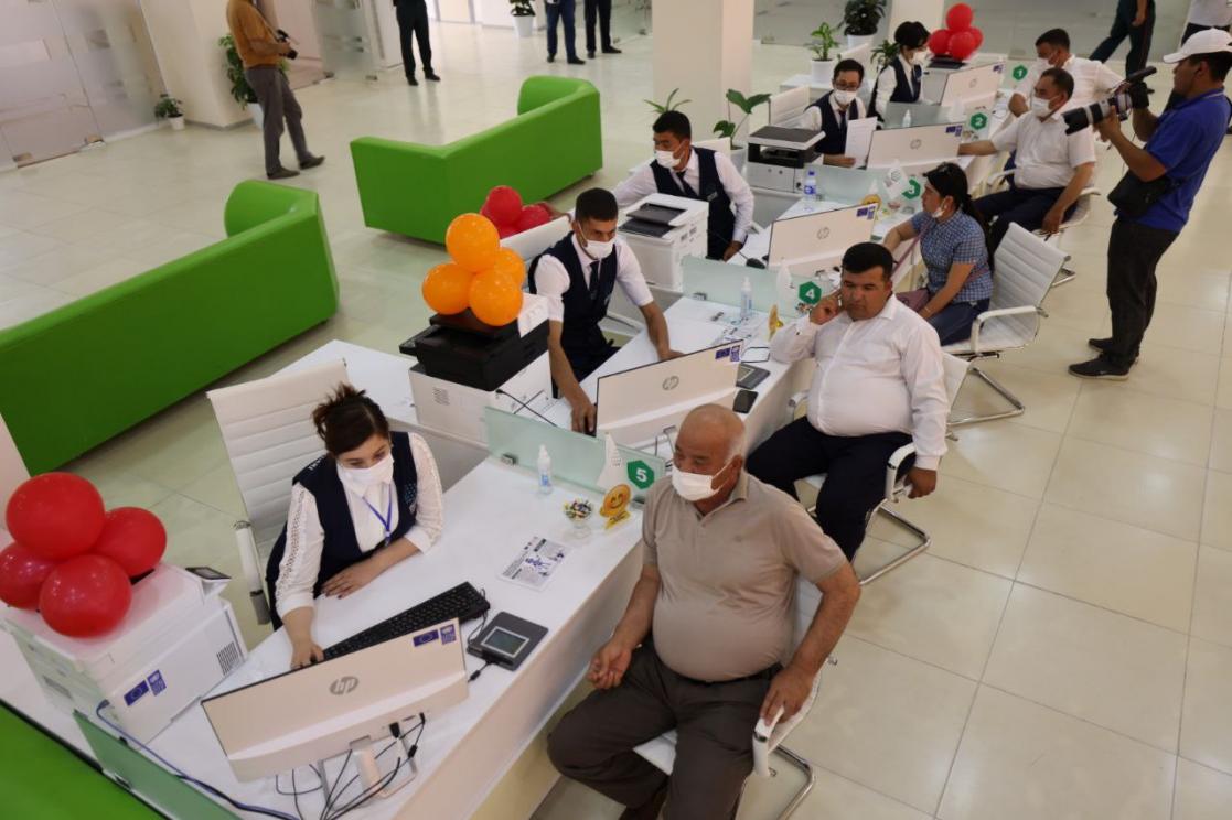 People sitting being served by officials