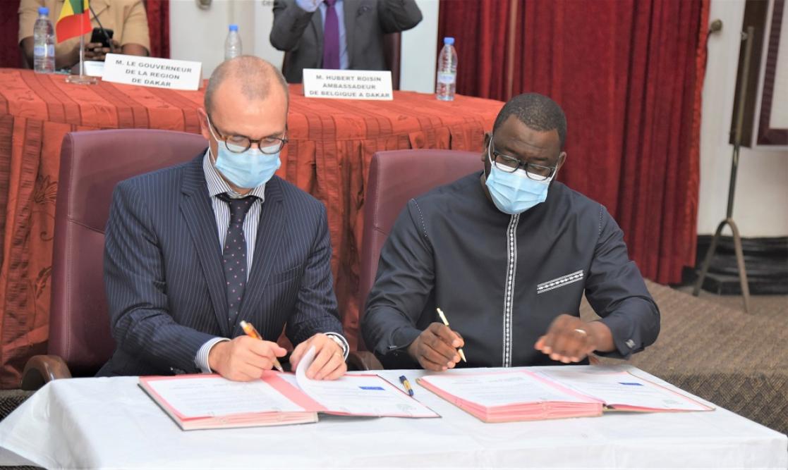 Two men signing documents