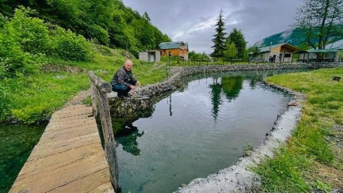 Man crouching on a river bank