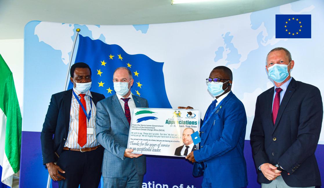Group of men on suit holding a poster