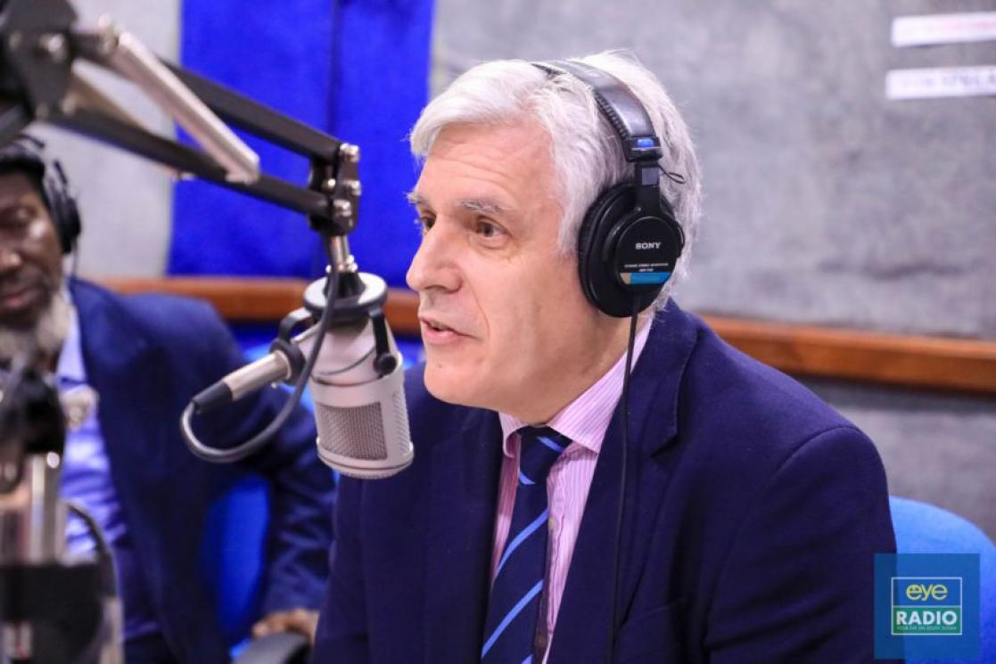 Man speaking to a microphone on a radio studio