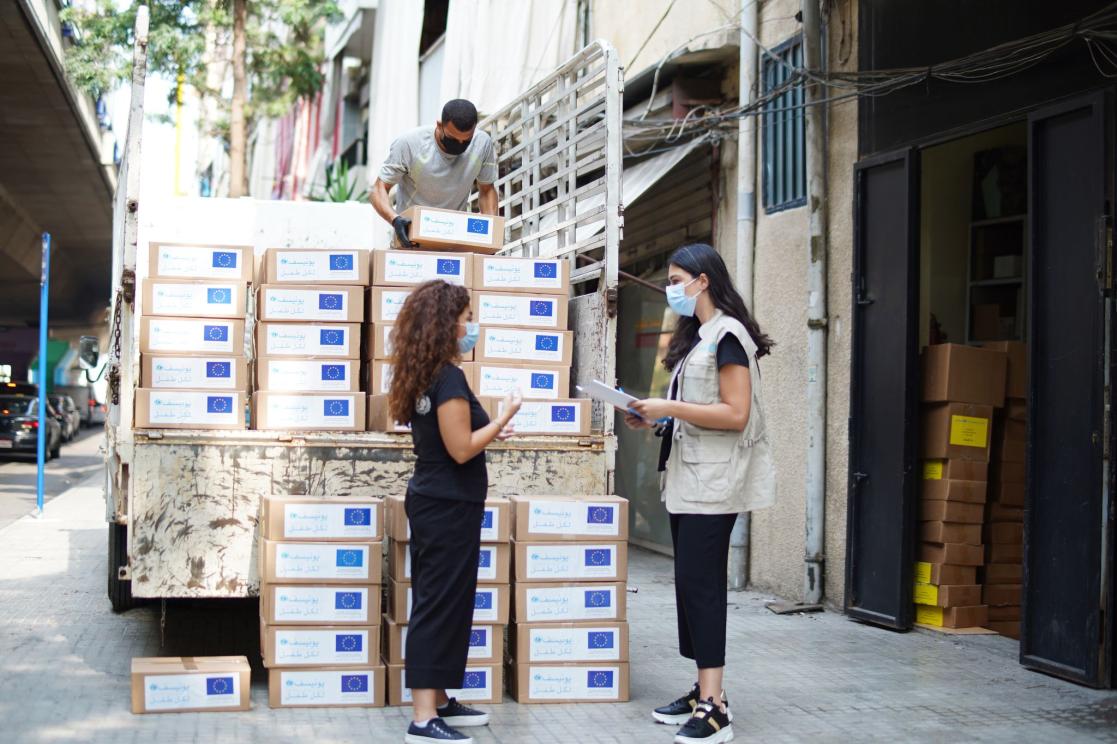group of people with lots of boxes in a truck helping them put them down