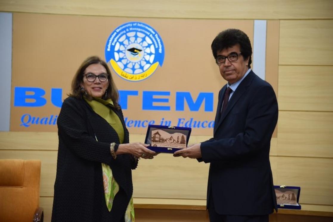 Man and woman posing holding an award