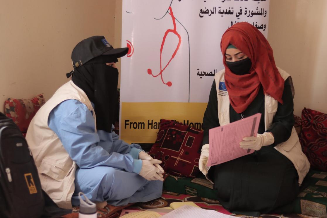 Women sitting on carpets reviewing documents