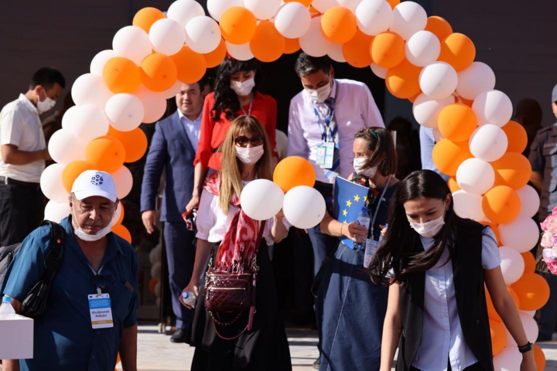 People crossing an arch made of balloons