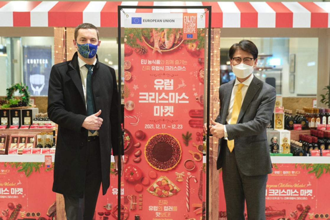 Two men posing with the red mock up of a Christmas market
