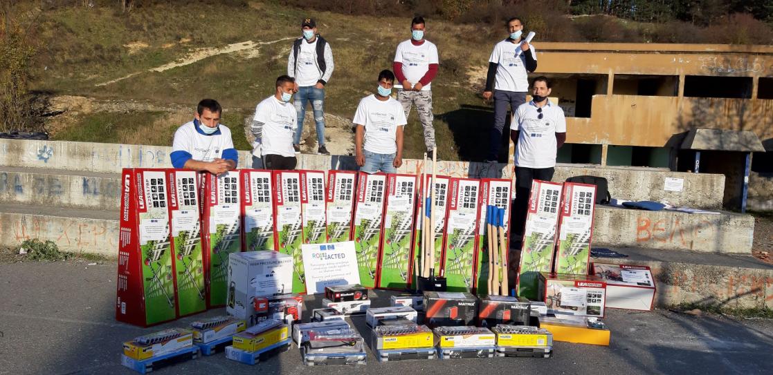 Group of people posing behind a bunch of equipment