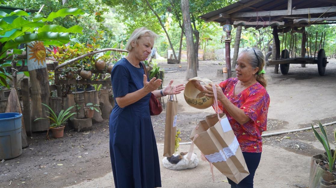 Two women admiring a piece of handicraft